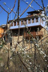 un edificio en la cima de una colina con flores blancas en Boutique Hotel Kokkino Spiti, en Veria