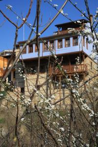 a building on top of a hill with white flowers at Boutique Hotel Kokkino Spiti in Veria