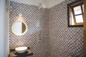 a tiled bathroom with a toilet and a mirror at Villa Johen in Boicucanga