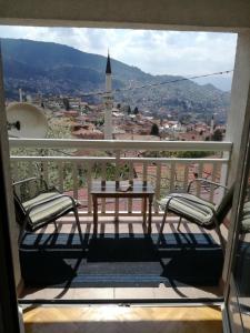 uma varanda com uma mesa e 2 cadeiras e uma vista em " Relax & Enjoy " em Sarajevo