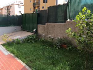 a yard with a fence and a green gate at Cooper Apartment in Genoa
