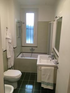 a bathroom with a toilet and a sink and a tub at Cooper Apartment in Genoa