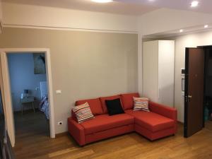 a red couch sitting in a living room at Cooper Apartment in Genoa
