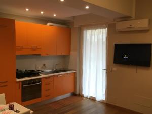 a kitchen with orange cabinets and a sink and a window at Cooper Apartment in Genoa