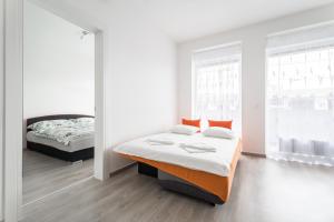1 dormitorio con 2 camas y 2 ventanas en BpR CHIC White Home with Terrace & A/C & Garage en Budapest