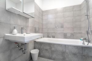 uma casa de banho com um lavatório e uma banheira em BpR CHIC White Home with Terrace & A/C & Garage em Budapeste