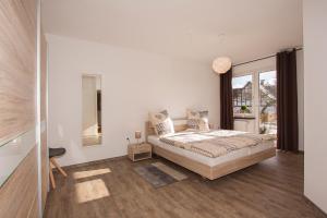 a white bedroom with a bed and a window at Ferienwohnungen Vollmers-Dünnebacke in Schmallenberg