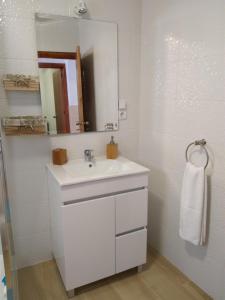 a white bathroom with a sink and a mirror at Casa da Rosarinha in Água de Alto +51 photos