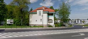un pequeño edificio al lado de una carretera en Czarna Owca- Pokoje Gościnne, en Gniezno