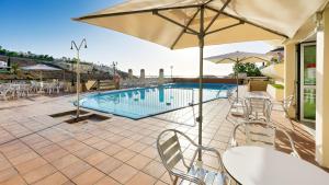 - Piscina con mesas, sillas y sombrilla en Ura Roslara, en Puerto Rico de Gran Canaria