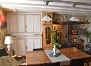 a dining room with a wooden table and chairs at L'embellie in Bertignat