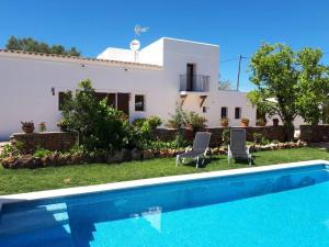 una villa con piscina di fronte a una casa di Casa Can Boletar a Santa Gertrudis de Fruitera