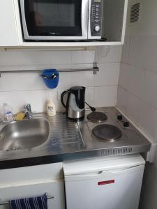 eine kleine Küche mit einer Spüle und einer Mikrowelle in der Unterkunft Paris Porte d'Orléans Cachan RER B direct JO Paris 2024 in Cachan