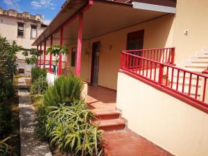 a house with a red railing on the balcony at Maison Etoile de Mer in Agnone Bagni