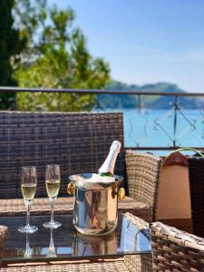 a bottle of wine in a bucket on a table with two glasses at Apartment Boreas in Strunjan