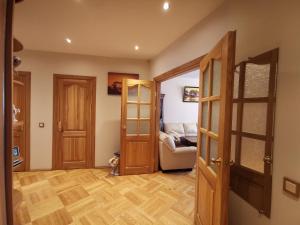 a living room with wooden doors and a couch at Tadas Apartaments in Vilnius