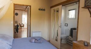 a bedroom with a blue bed and a bathroom at la souquette in Draguignan