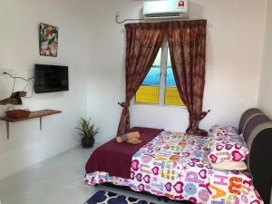 a bedroom with a bed and a window at Lakse Inn Homestay in Kampong Pengkalan Maras