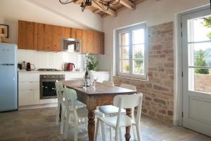 a kitchen with a wooden table and white chairs at Casale Biancopecora in SantʼElpidio Morico