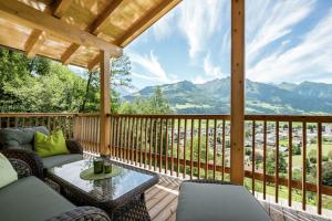 a porch with a couch and a table on a deck at alpin penthouse in Piesendorf
