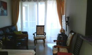 a living room with chairs and a large window at Condominio Costamar in Coquimbo