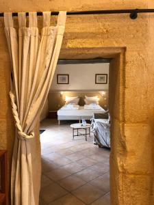 1 dormitorio con cama y ventana grande en Domaine du Champ de l'Hoste, en Larzac