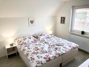 1 dormitorio con 1 cama con colcha de flores en Guest house Kobal, en Zgornje Gorje