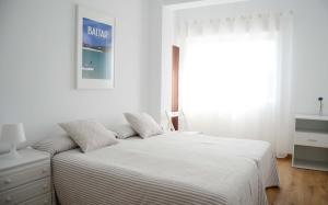 biała sypialnia z łóżkiem i oknem w obiekcie Apartamento Ana w mieście Portonovo