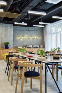 una sala da pranzo con tavoli e sedie con piante di Hotel Arche Geologiczna a Varsavia