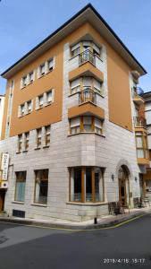 a tall building with windows and a balcony at Hotel Plaza in Cangas de Onís