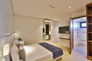 a bedroom with a large bed and a television at Quality Hotel Blumenau in Blumenau