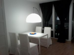 a white dining room table with white chairs and a light at Thomaskirchhof 8 in Leipzig