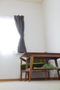 a coffee table with a plant on it next to a window at Hummingbird Kanazawa in Kanazawa