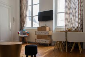 a living room with a tv and a table and chairs at la Casa D'estève in Bourges