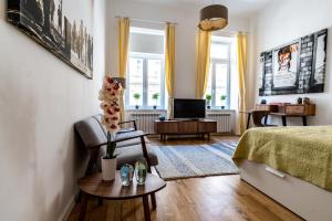 a living room with a bed and a tv at Boutique Prater Apartments Vienna in Vienna