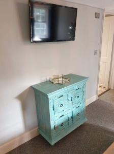 a blue cabinet with a television on a wall at The Horse Inn Hurst in Hurstpierpoint