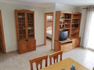ein Wohnzimmer mit einem Esstisch und einem TV in der Unterkunft Solmar II Solo Familias Serviplaya in Platja de Xeraco