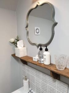 Baño con espejo en un estante sobre un fregadero en The Horse Inn Hurst en Hurstpierpoint