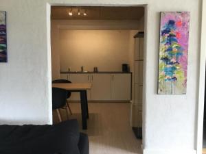 uma sala de estar com uma mesa e uma cozinha em Århus nord bed and breakfast em Hinnerup