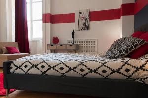 a bedroom with a bed with red and white stripes at la Casa D'estève in Bourges