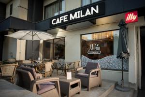 a cafe milan with chairs and tables and an umbrella at Hostal La Cumbre in Temuco