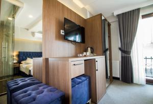 アヴシラーにあるHit Suites Avcilar Hotelのホテルルーム(ベッド1台、青いソファ付)