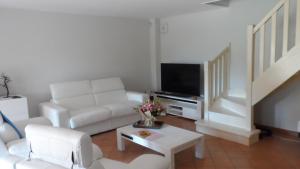 a living room with a couch and a tv at Villa 47 Hameau des Greens in Sainte-Maxime