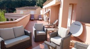 a patio with wicker chairs and tables on a balcony at Villa 47 Hameau des Greens in Sainte-Maxime