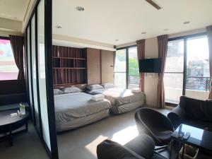 a hotel room with a bed and a living room at Tainan Chuan Inn A in Tainan