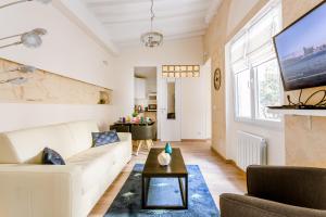 a living room with a white couch and a tv at Marais Saint Paul Ecouffes in Paris