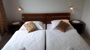 een slaapkamer met 2 bedden met witte lakens en kussens bij Apartamenty Panorama in Rychwałd