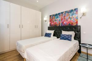 2 camas en un dormitorio con una pintura en la pared en Marais Saint Paul Ecouffes en París