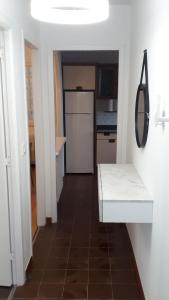 サンティアゴ・デ・コンポステーラにあるPR Blancoのタイルフロアのキッチン(白い冷蔵庫付)
