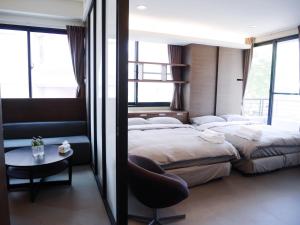 a hotel room with two beds and a table at Tainan Chuan Inn A in Tainan